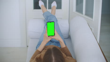 Phone-with-Green-Screen-and-Chroma-Key-Closeup.-Chromakey-Mockup-with-Tracking-Markers-and-Alpha-Matte.-POV-is-Vertical-Template-of-Device-in-Modern-House-Closeup.-Scroll-Up-Online-News-at-Cellphone